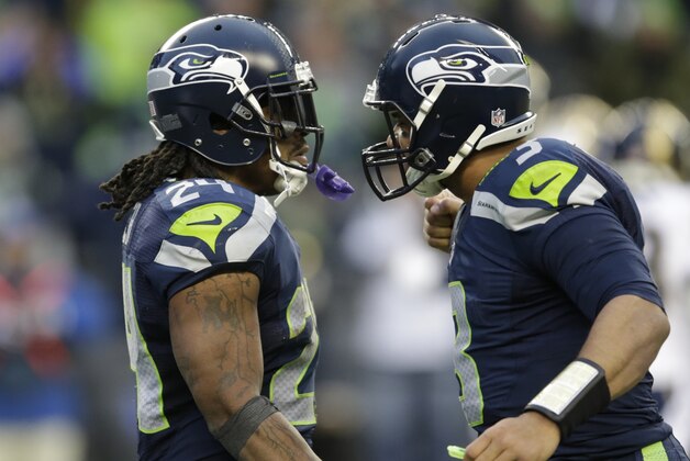 Seattle Seahawks quarterback Russell Wilson, right, greets running back Marshawn Lynch, left, after Lynch scored a touchdown agains the St. Louis Rams in the second half of an NFL football game, Sunday, Dec. 28, 2014, in Seattle. (AP Photo/Scott Eklund)