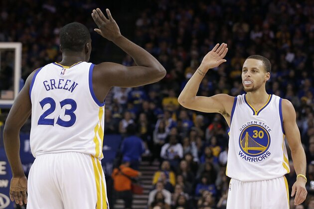 Golden State Warriors forward Draymond Green (23) and guard Stephen Curry (30) greet during the first half of an NBA basketball game against the Philadelphia 76ers in Oakland, Calif., Tuesday, Dec. 30, 2014. The Warriors won 126-86. (AP Photo/Jeff Chiu)