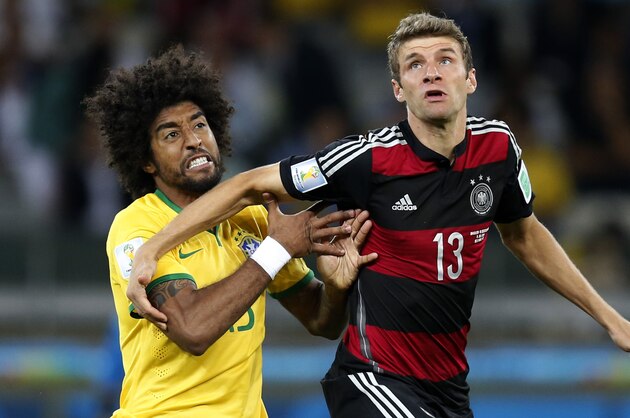 Brazil's Dante, left, and Germany's Thomas Mueller, right, challenge for the ball during the World Cup semifinal soccer match between Brazil and Germany at the Mineirao Stadium in Belo Horizonte, Brazil, Tuesday, July 8, 2014. (AP Photo/Frank Augstein)