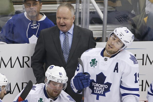 Toronto Maple Leafs head coach Randy Carlyle stands behind Phil Kessel (81), and Joffrey Lupul (19) during the third period of an NHL hockey game against the Pittsburgh Penguins in Pittsburgh Wednesday, Nov. 26, 2014. The Penguins won 4-3 in overtime. (AP Photo/Gene J. Puskar