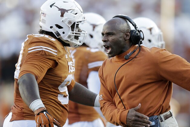 Texas Longhorns head coach Charlie Strong, right, celebrates with Malcom Brown, left, during the second half of an NCAA college football game against West Virginia, Saturday, Nov. 8, 2014, in Austin, Texas.  Texas won 33-16. (AP Photo/Eric Gay)