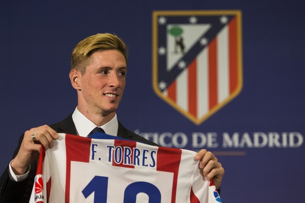 Spanish forward Fernando Torres holds his new Atletico de Madrid shirt as he poses for photographers during his presentation at the Vicente Calderon stadium in Madrid, Spain, Sunday, Jan. 4, 2015. (AP Photo/Andres Kudacki)
