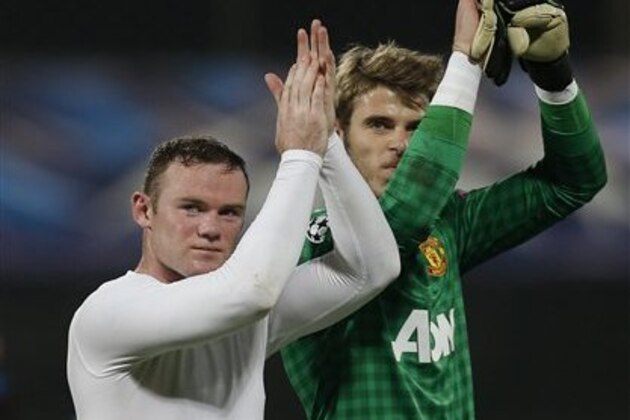 Manchester United's Wayne Rooney, left, and keeper David de Gea, right, salute supporters after their team defeated CFR Cluj  in Cluj, Romania, Tuesday, Oct. 2, 2012, in an UEFA Champions League, Group H, soccer match.(AP Photo/Vadim Ghirda)