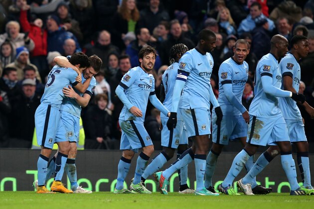 MANCHESTER, ENGLAND - JANUARY 04:  James Milner (2nd L) of Manchester City celebrates with Jesus Navas of Manchester City (L) after scoring his team's second goal to take a 2-1 lead during the FA Cup Third Round match between  Manchester City and Sheffield Wednesday at Etihad Stadium on January 4, 2015 in Manchester, England.  (Photo by Jan Kruger/Getty Images)