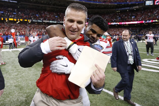 Jan 1, 2015; New Orleans, LA, USA; Ohio State Buckeyes head coach Urban Meyer is hugged by running back Ezekiel Elliott (15) after the 2015 Sugar Bowl against the Alabama Crimson Tide at Mercedes-Benz Superdome. Ohio State defeated Alabama 42-35. Mandatory Credit:  Matthew Emmons-USA TODAY Sports