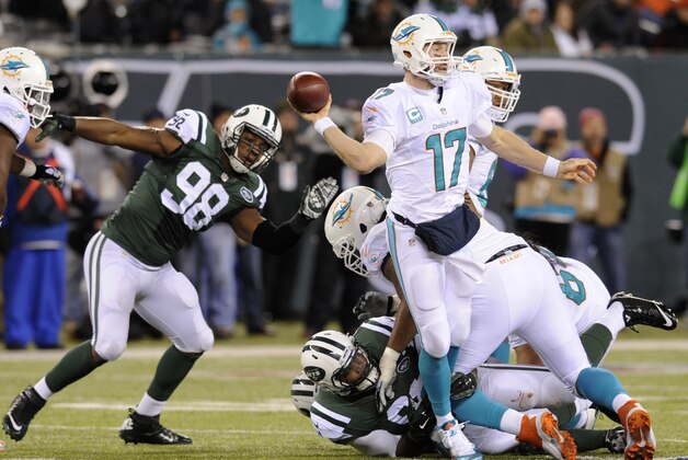 Miami Dolphins quarterback Ryan Tannehill (17) throws a pass under pressure from the New York Jets during the third quarter of an NFL football game, Monday, Dec. 1, 2014, in East Rutherford, N.J. Miami Dolphins running back Lamar Miller (26) tipped the pass on the play resulting in an interception for the Jets. (AP Photo/Bill Kostroun)