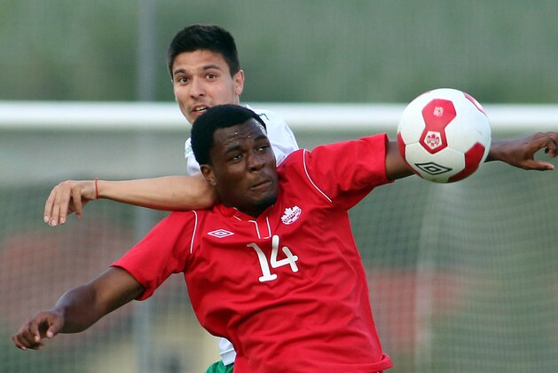 Canada's Cyle Larin, front, challenges for a ball with Ilia Milanov, back, of Bulgaria during a friendly soccer match between Canada and Bulgaria, in Ritzing, Austria, Friday, May 23, 2014. (AP Photo/Ronald Zak)