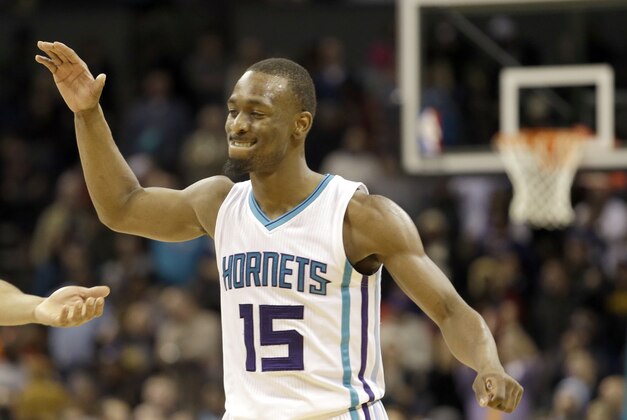 Charlotte Hornets' Gerald Henderson (9) and other teammates prepare to celebrate with Kemba Walker (15) after Walker hit the winning shot against the New Orleans Pelicans during the second half of an NBA basketball game in Charlotte, N.C., Wednesday Jan. 7, 2015. The Hornets won 98-94. (AP Photo/Bob Leverone)