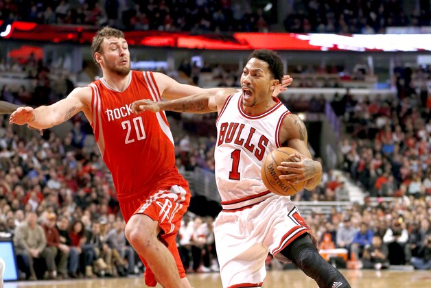 Chicago Bulls guard Derrick Rose (1) drives on Houston Rockets forward Donatas Motiejunas (20) during the second half of an NBA basketball game Monday, Jan. 5, 2015, in Chicago. The Bulls won 114-105. (AP Photo/Charles Rex Arbogast)
