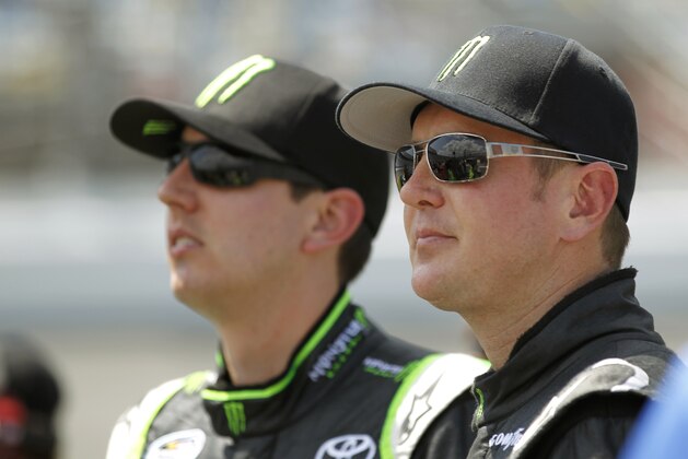 Kyle Busch, left, and brother Kurt Busch wait to qualify for the Nationwide Series NASCAR Subway Jalapeno 250 auto race at Daytona International Speedway, Friday, July 6, 2012, in Daytona Beach, Fla. (AP Photo/Terry Renna)