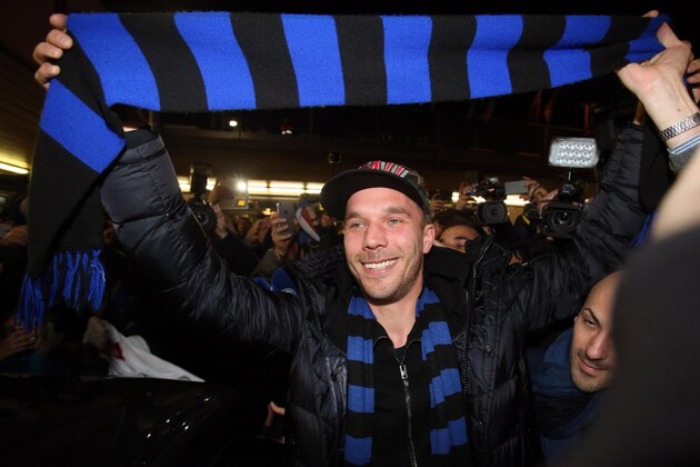 German forward Lukas Podolski holds up an Inter Milan scarf as he arrives at the Linate airport, Milan, Italy, Friday, Jan. 2, 2015. Podolski is joining the Serie A club Inter Milan. (AP Photo/Ansa/Matteo Bazzi)
