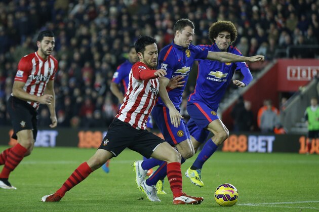 Southampton’s Maya Yoshida, second left, attempts to get a shot on goal under pressure from Manchester United’s Jonny Evans during their English Premier League soccer match between Southampton and Manchester United at St Mary's stadium in Southampton, England, Monday, Dec. 8, 2014. (AP Photo/Alastair Grant)