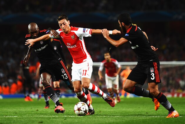 LONDON, ENGLAND - AUGUST 27:  Mesut Oezil (C) of Arsenal holds off the challenge of Atiba Hutchinson (L) of Besiktas and Ismail Koybasl (R) of Besiktas during the UEFA Champions League Qualifier 2nd leg match between Arsenal and Besiktas at the Emirates Stadium on August 27, 2014 in London, United Kingdom.  (Photo by Shaun Botterill/Getty Images)