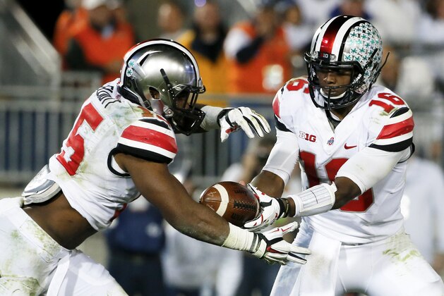 Ohio State quarterback J.T. Barrett (16) hands off to running back Ezekiel Elliott (15) during the second half of an NCAA college football game in State College, Pa., Saturday, Oct. 25, 2014. (AP Photo/Gene J. Puskar)