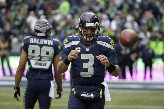 Seattle Seahawks quarterback Russell Wilson catches the ball during warmups before an NFL football game against the St. Louis Rams, Sunday, Dec. 28, 2014, in Seattle. (AP Photo/Elaine Thompson)