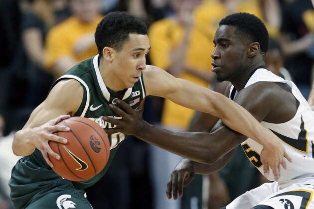 Michigan State guard Travis Trice, left, drives past Iowa guard Anthony Clemmons during the second half of an NCAA college basketball game, Thursday, Jan. 8, 2015, in Iowa City, Iowa. Trice scored 25 points as Michigan State won 75-61. (AP Photo/Charlie Neibergall)