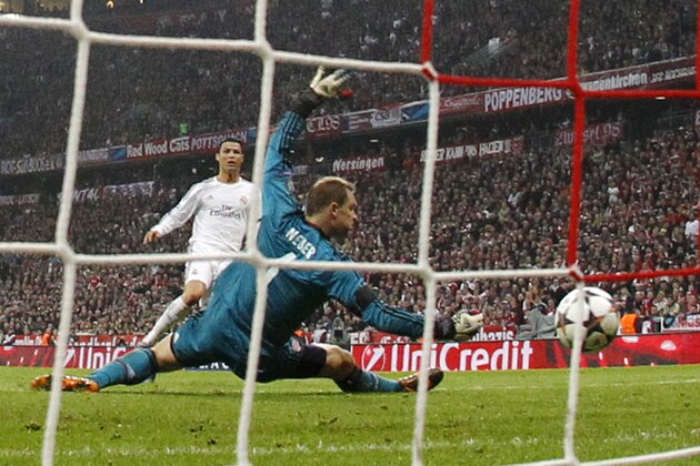 Real's Cristiano Ronaldo, left, scores his side's 3rd goal past Bayern goalkeeper Manuel Neuer during the Champions League semifinal second leg soccer match between Bayern Munich and Real Madrid at the Allianz Arena in Munich, southern Germany, Tuesday, April 29, 2014. (AP Photo/Matthias Schrader)