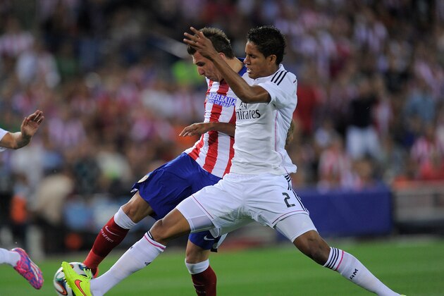 MADRID, SPAIN - AUGUST 22:  Mario Mandzukic of Club Atletico de Madrid beats Raphael Varane of Real Madrid to score his team's opening goal during the Supercopa, second leg match between Club Atletico de Madrid and Real Madrid at Vicente Caldron stadium on August 22, 2014 in Madrid, Spain.  (Photo by Denis Doyle/Getty Images)