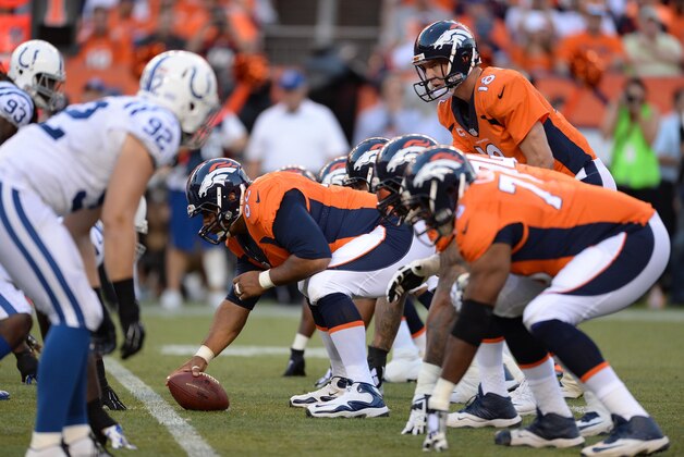 Sep 7, 2014; Denver, CO, USA; Denver Broncos quarterback Peyton Manning (18) lines up behind center Manny Ramirez (66) in the first quarter against the Indianapolis Colts at Sports Authority Field at Mile High. Mandatory Credit: Ron Chenoy-USA TODAY Sports
