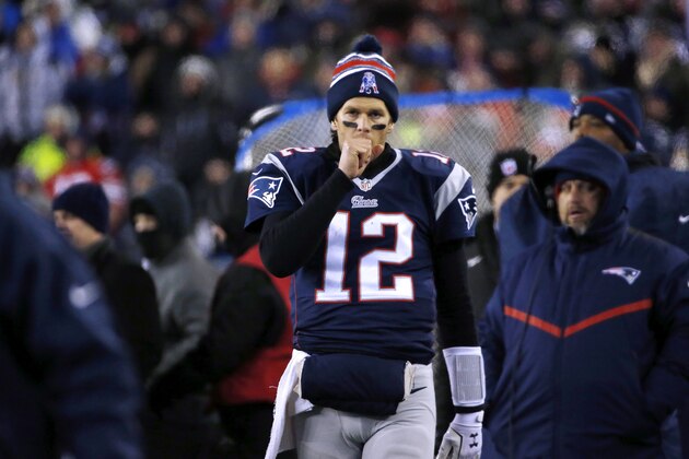 New England Patriots quarterback Tom Brady warms his throwing hand on the sideline in the second half of an NFL divisional playoff football game against the Baltimore Ravens Saturday, Jan. 10, 2015, in Foxborough, Mass. (AP Photo/Elise Amendola)