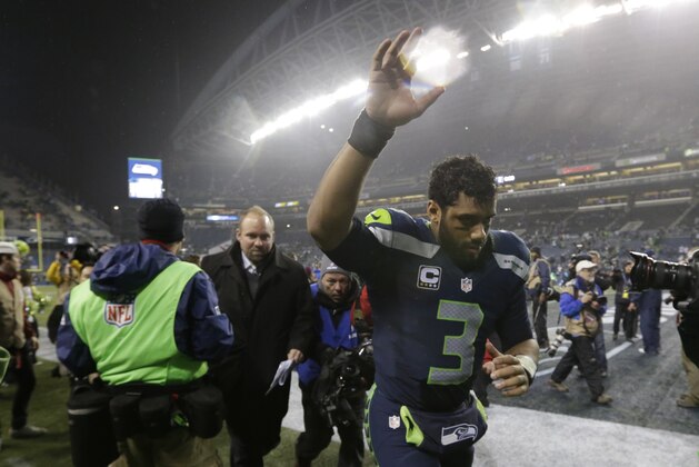 Seattle Seahawks quarterback Russell Wilson runs off the field after an NFL divisional playoff football game against the Carolina Panthers in Seattle, Saturday, Jan. 10, 2015. The Seahawks won 31-17. (AP Photo/Elaine Thompson)