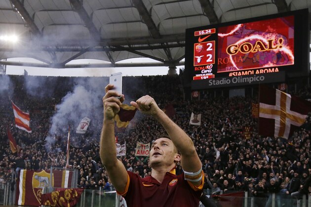 Roma's Francesco Totti celebrates with a selfie after scoring during a Serie A soccer match between Roma and Lazio at Rome's Olympic stadium, Sunday, Jan. 11, 2015. (AP Photo/Gregorio Borgia)