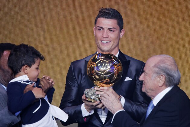 Real Madrid's world player Christiano Ronaldo of Portugal, center, FIFA President Joseph Blatter and Ronaldo's son Ronaldo Junior stand together at the FIFA Ballon d'Or 2013 Gala in Zurich, Switzerland, Monday, Jan. 13, 2014. (AP Photo/Michael Probst)