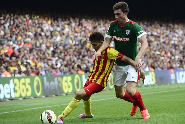 FC Barcelona's Munir El Haddadi Mohamed, left, duels for the ball against Athletic Bilbao's Aymeric Laporte during a Spanish La Liga soccer match at the Camp Nou stadium in Barcelona, Spain, Saturday, Sept. 13, 2014. (AP Photo/Manu Fernandez)