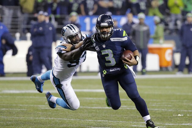 Seattle Seahawks quarterback Russell Wilson (3) runs against Carolina Panthers defensive end Mario Addison (97) during the second half of an NFL divisional playoff football game in Seattle, Saturday, Jan. 10, 2015. (AP Photo/Ted S. Warren)