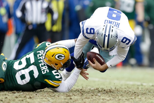 GREEN BAY, WI - JANUARY 11:   Tony Romo #9 of the Dallas Cowboys recovers his fumble against  Julius Peppers #56 of the Green Bay Packers during the 2015 NFC Divisional Playoff game at Lambeau Field on January 11, 2015 in Green Bay, Wisconsin.  (Photo by Mike McGinnis/Getty Images)