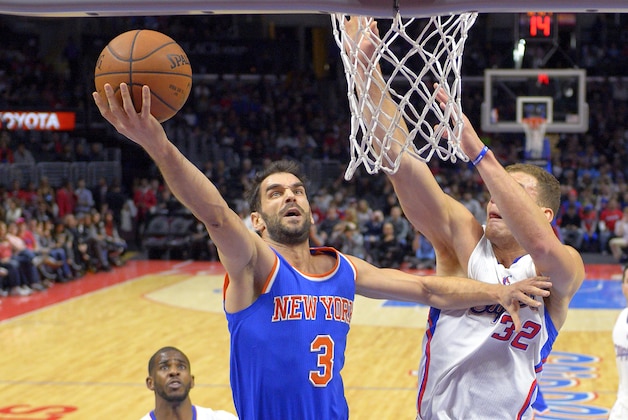 New York Knicks guard Jose Calderon, center, of Spain, shoots as Los Angeles Clippers forward Blake Griffin, right, defends and guard Chris Paul looks on during the first half of an NBA basketball game, Wednesday, Dec. 31, 2014, in Los Angeles. (AP Photo/Mark J. Terrill)