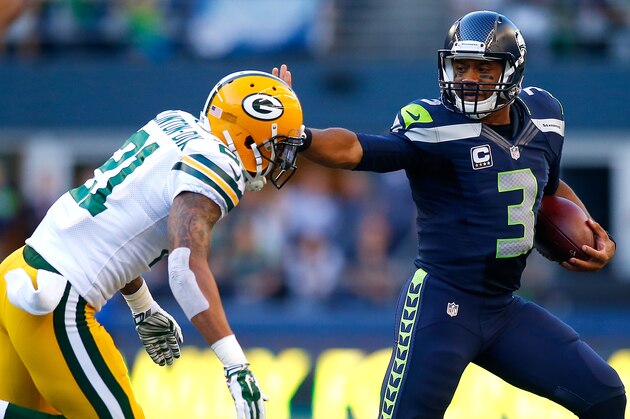 SEATTLE - SEPTEMBER 04:  Quaterback Russell Wilson #3 of the Seattle Seahawks escapes the tackle attempt of safety Ha Ha Clinton-Dix #21 of the Green Bay Packers at CenturyLink Field on September 4, 2014 in Seattle, Washington.  (Photo by Jonathan Ferrey/Getty Images)