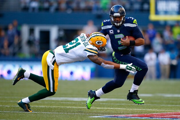 SEATTLE - SEPTEMBER 04:  Quaterback Russell Wilson #3 of the Seattle Seahawks escapes the tackle attempt of safety Ha Ha Clinton-Dix #21 of the Green Bay Packers at CenturyLink Field on September 4, 2014 in Seattle, Washington.  (Photo by Jonathan Ferrey/Getty Images)