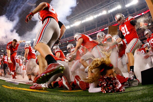 ARLINGTON, TX - JANUARY 12:  A Ohio State Buckeyes cheerleader falls as the Buckeyes run out to the field before the College Football Playoff National Championship Game at AT&T Stadium on January 12, 2015 in Arlington, Texas.  (Photo by Tom Pennington/Getty Images)