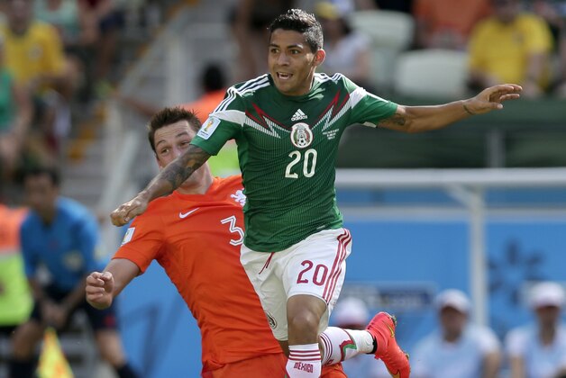 Mexico's Javier Aquino, right, controls the ball past Netherlands' Stefan de Vrij during the World Cup round of 16 soccer match between the Netherlands and Mexico at the Arena Castelao in Fortaleza, Brazil, Sunday, June 29, 2014. (AP Photo/Marcio Jose Sanchez)