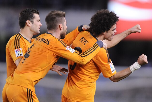 Real Madrid's Pepe of Portugal, right, celebrates his goal and the third of his team with Jose Nacho, left, and Sergio Ramos, after scoring against Real Sociedad, during their Spanish League soccer match, at Anoeta stadium, in San Sebastian, Spain, Saturday, April 5, 2014. (AP Photo/Alvaro Barrientos)