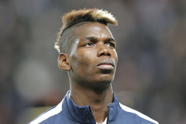 France's Paul Pogba, stands at attention during the Albanian National anthem prior to the start of a friendly soccer match France against Albania at Route de Lorient stadium in Rennes, western France, Friday, Nov. 14, 2014. The match ended in a 1-1 draw. (AP Photo/Michel Euler)