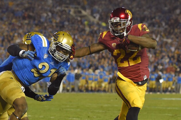 Southern California running back Justin Davis, right, stiff-arms UCLA defensive back Tahaan Goodman on his way in for a touchdown during the first half of an NCAA college football game, Saturday, Nov. 22, 2014, in Pasadena, Calif. (AP Photo/Mark J. Terrill)