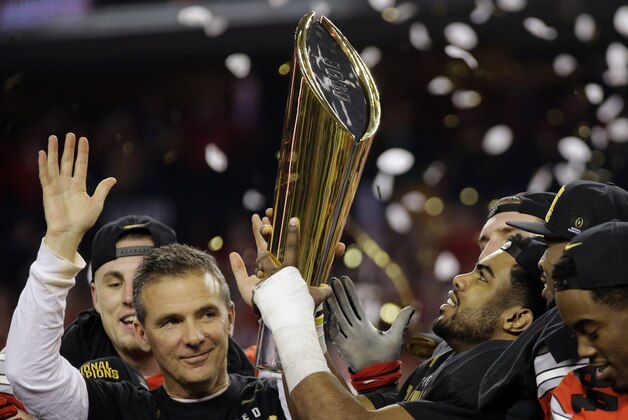 Ohio State head coach Urban Meyer and Ezekiel Elliott celebrate after the NCAA college football playoff championship game against Oregon Monday, Jan. 12, 2015, in Arlington, Texas. Ohio State won 42-20. (AP Photo/Eric Gay)