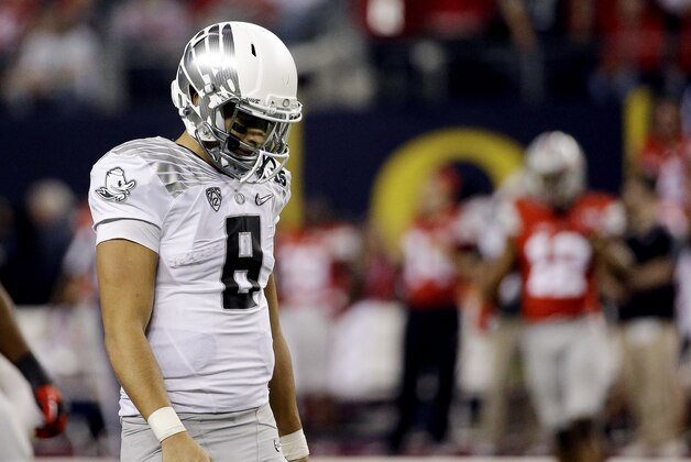 Oregon's Marcus Mariota walks off the field during the second half of the NCAA college football playoff championship game against Ohio State Monday, Jan. 12, 2015, in Arlington, Texas. (AP Photo/David J. Phillip)