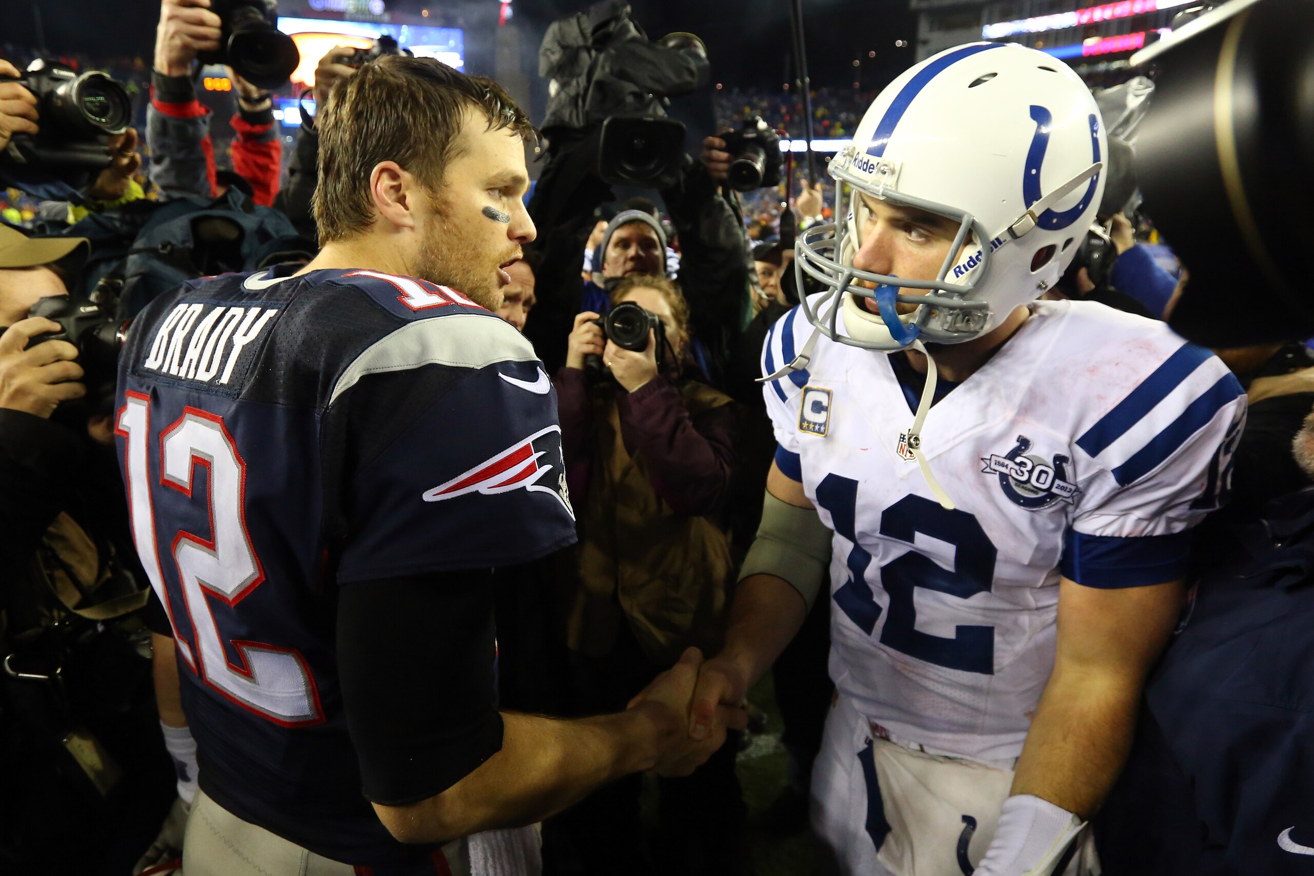 FOXBORO, MA - JANUARY 11:  (L-R) Tom Brady #12 of the New England Patriots shakes hands with Andrew Luck #12 of the Indianapolis Colts after their AFC Divisional Playoff game at Gillette Stadium on January 11, 2014 in Foxboro, Massachusetts. The New England Patriots defeated the Indianapolis Colts 43 to 22.  (Photo by Al Bello/Getty Images)