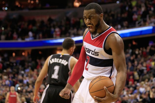 WASHINGTON, DC - JANUARY 13:  John Wall #2 of the Washington Wizards celebrates in front of Kyle Anderson #1 of the San Antonio Spurs after the Wizards defeated the Spurs 101-93 at Verizon Center on January 13, 2015 in Washington, DC. NOTE TO USER: User expressly acknowledges and agrees that, by downloading and or using this photograph, User is consenting to the terms and conditions of the Getty Images License Agreement.  (Photo by Rob Carr/Getty Images)