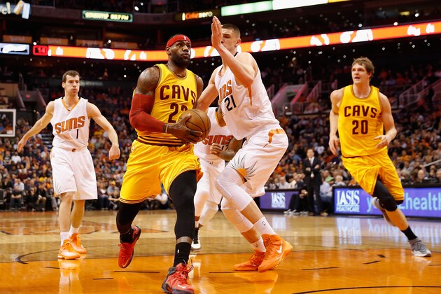PHOENIX, AZ - JANUARY 13:  LeBron James #23 of the Cleveland Cavaliers drives the ball past Alex Len #21 of the Phoenix Suns during the first half of the NBA game at US Airways Center on January 13, 2015 in Phoenix, Arizona.  NOTE TO USER: User expressly acknowledges and agrees that, by downloading and or using this photograph, User is consenting to the terms and conditions of the Getty Images License Agreement.  (Photo by Christian Petersen/Getty Images)
