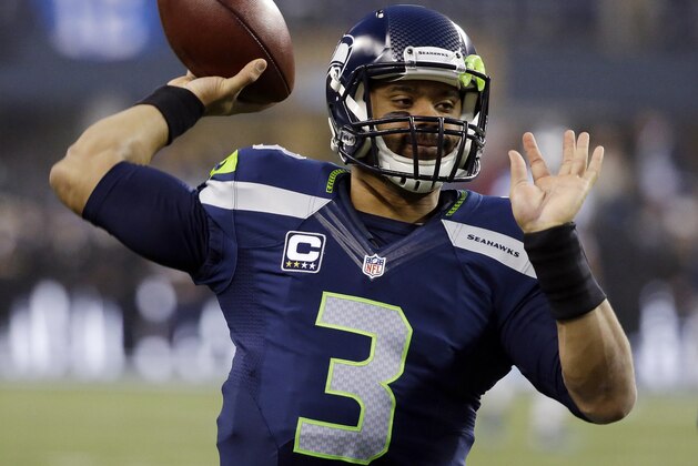 Seattle Seahawks quarterback Russell Wilson (3) throws during warmups before an NFL divisional playoff football game against the Carolina Panthers in Seattle, Saturday, Jan. 10, 2015. (AP Photo/Elaine Thompson)