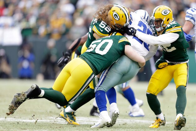 GREEN BAY, WI - JANUARY 11:   DeMarco Murray #29 of the Dallas Cowboys is tackled by  A.J. Hawk #50,  Clay Matthews #52 and  Morgan Burnett #42 of the Green Bay Packers in the first quarter during the 2015 NFC Divisional Playoff game at Lambeau Field on January 11, 2015 in Green Bay, Wisconsin.  (Photo by Mike McGinnis/Getty Images)