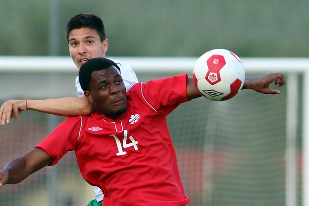 Canada's Cyle Larin, front, challenges for a ball with Ilia Milanov, back, of Bulgaria during a friendly soccer match between Canada and Bulgaria, in Ritzing, Austria, Friday, May 23, 2014. (AP Photo/Ronald Zak)