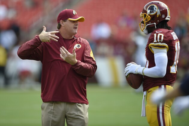 Washington Redskins head coach Jay Gruden, right, talks with quarterback Robert Griffin III (10) before an NFL football game against the Jacksonville Jaguars, Sunday, Sept. 14, 2014, in Landover, Md. (AP Photo/Nick Wass)