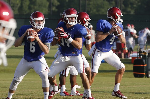 In this Tuesday, Aug. 5, 2014 photo, Oklahoma quarterbacks Baker Mayfield (6), Cody Thomas (14), Trevor Knight (9), Justice Hansen (4) prepare to throw during a team practice in Norman, Okla. (AP Photo/Sue Ogrocki)