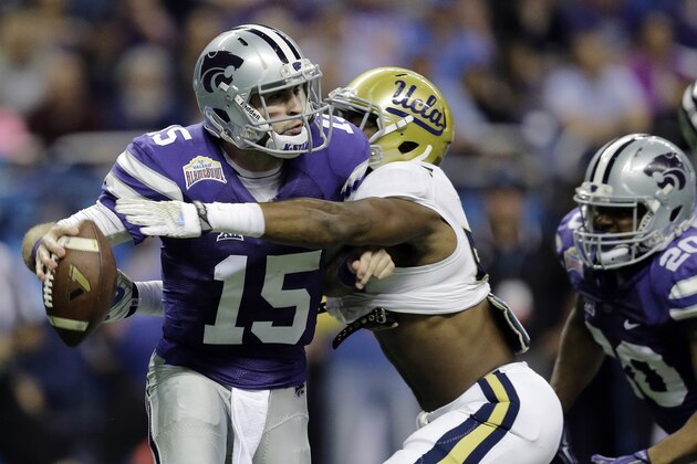 Kansas State’s Jake Waters (15) is hit by UCLA's Deon Hollins as he tries to pass during the first half of the Alamo Bowl NCAA college football game, Friday, Jan. 2, 2015, in San Antonio. (AP Photo/Eric Gay)