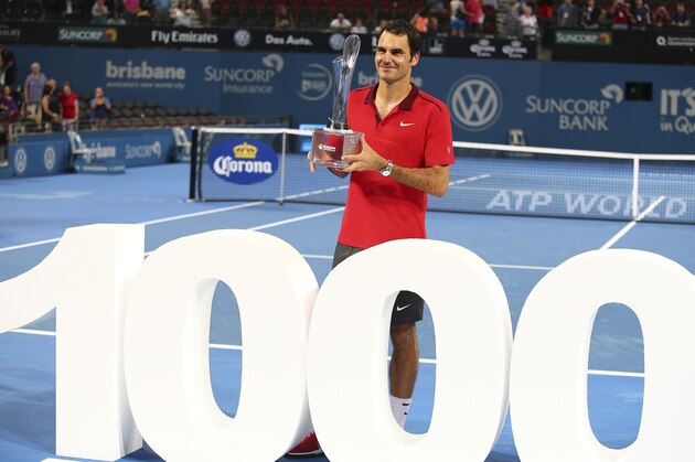 Roger Federer of Switzerland holds the winner's trophy and pose for photos after he won his 1000th career title in the men's final match against Milos Raonic of Canada during the Brisbane International tennis tournament in Brisbane, Australia, Sunday, Jan. 11, 2015. Federer notched his 1,000th career victory and collected his 83rd title with a seesawing 6-4, 6-7 (2), 6-4 win over third-seeded Milos Raonic of Canada in the Brisbane International final on Sunday. (AP Photo/Tertius Pickard)